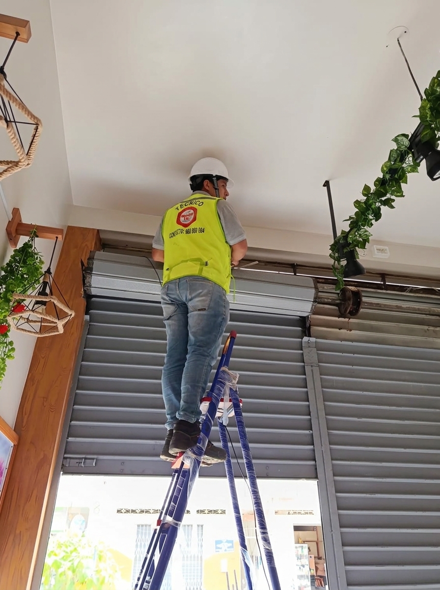 Técnico de Domo Tec instalando equipo de seguridad en el interior de un negocio