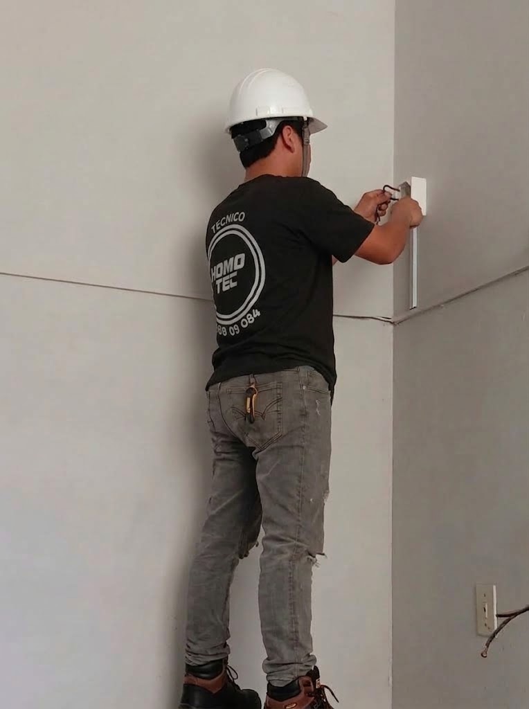 Técnico de Domo Tec cableando un punto de red para el sistema de cámaras